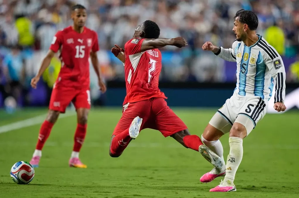 Paredes (phải) va chạm với Breel Embolo...