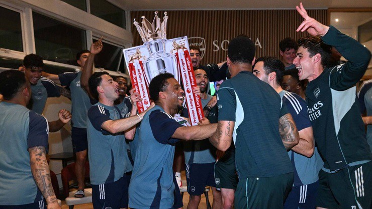 Các cầu thủ Arsenal ăn mừng cuồng nhiệt cùng mô hình cúp Premier League bằng bìa cứng