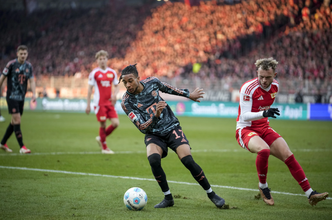 Michael Olise (trái) tranh chấp bóng trong trận Bayern Munich gặp Union Berlin trên sân An der Alten Försterei, Berlin, Đức, ngày 15/3/2025. Ảnh: AP