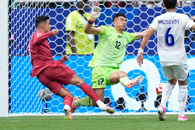 Cristiano Ronaldo (trái) va chạm với thủ môn Abduvohid Nematov trong nỗ lực dứt điểm ở trận Bồ Đào Nha gặp Uzbekistan tại bảng K World Cup 2026 trên sân Houston ngày 23/6. Ảnh: AP