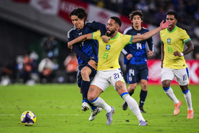 Tiền vệ Ao Tanaka (áo xanh) của Nhật Bản tranh chấp với Matheus Cunha của Brazil trong trận Nhật Bản thắng Brazil 3-2 ở giải giao hữu Kirin Challenge Cup, trên sân Tokyo ở Nhật Bản ngày 14/10/2025. Ảnh: AFP