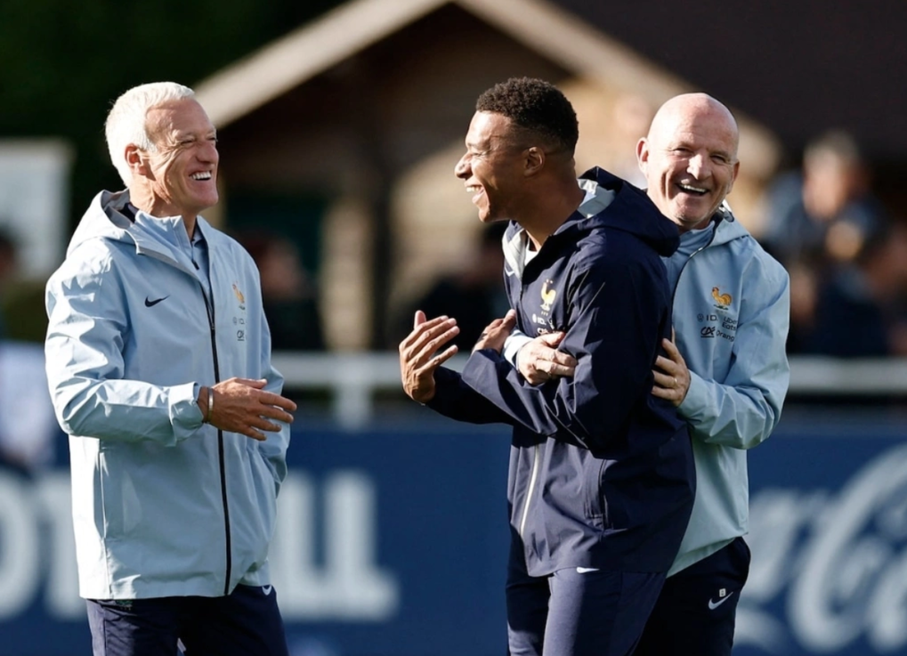 Trợ lý Guy Stephan (phải) cười đùa và trao đổi với Kylian Mbappe (giữa) và HLV Didier Deschamps buổi tập của tuyển Pháp tại Clairefontaine ngày 1/9/2025. Ảnh: Reuters