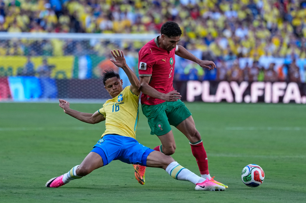 Douglas Santos (áo vàng) tranh chấp bóng với Achraf Hakimi trong trận Morocco hòa Brazil 1-1 ở bảng C World Cup 2026, trên sân MetLife, Đông Rutherford, New Jersey, Mỹ ngày 13/6. Ảnh: Reuters