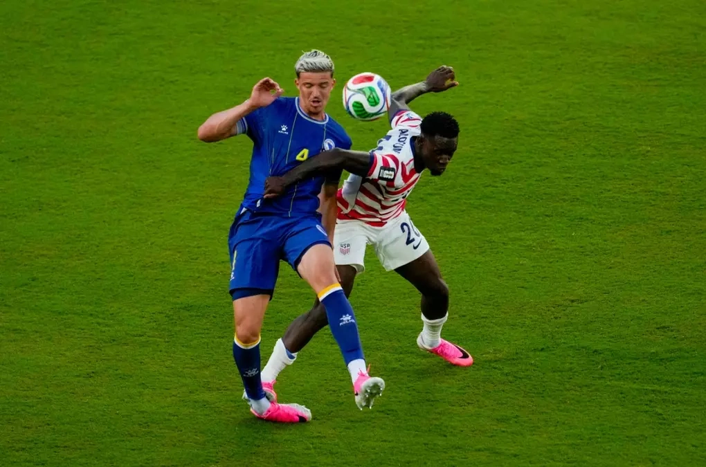 Tiền đạo Mỹ Folarin Balogun (20) phạm lỗi với Tarik Muharemovic (4) trong trận Mỹ gặp Bosnia & Herzegovina ở vòng 1/16 World Cup 2026, trên sân San Francisco Bay Area tại Mỹ, ngày 1/7/2026. Ảnh: AP
