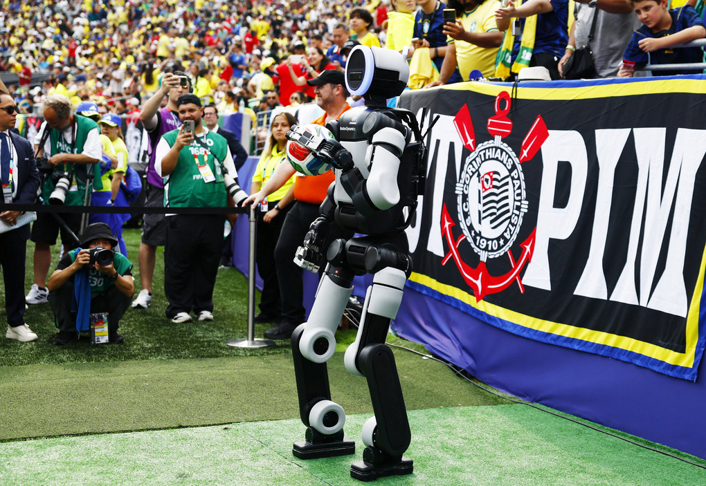 Robot hình người Atlas của Boston Dynamics mang quả bóng ra sân MetLife trước khi hiệp hai của trận Brazil - Na Uy vòng 1/8 World Cup bắt đầu. Ảnh: Reuters