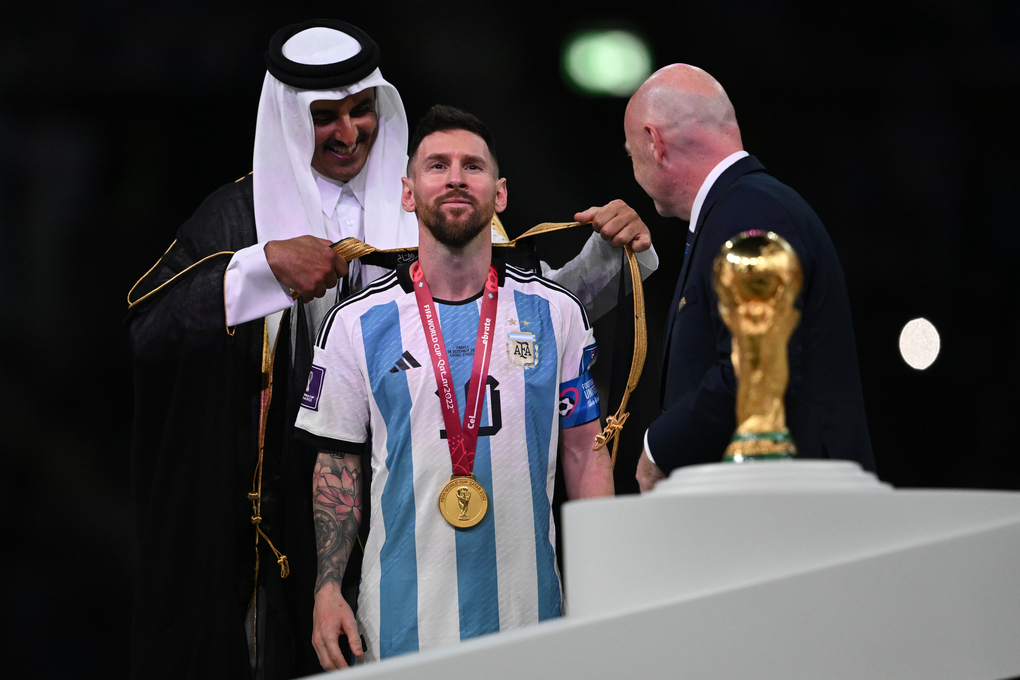 Tiểu vương Qatar (trái) khoác áo choàng Hồi giáo lên người cầu thủ Lionel Messi sau trận chung kết World Cup 2022 ở Lusail, Qatar, ngày 18/12. Ảnh: AFP