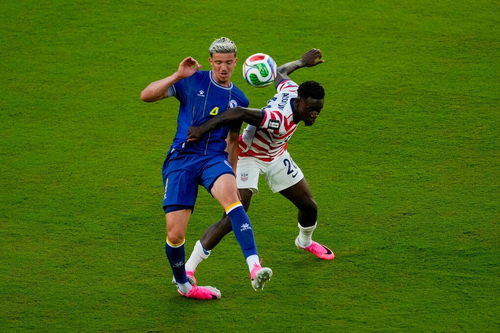 Tiền đạo Mỹ Folarin Balogun (20) phạm lỗi với Tarik Muharemovic (4) trong trận Mỹ gặp Bosnia & Herzegovina ở vòng 1/16 World Cup 2026, trên sân San Francisco Bay Area tại Mỹ, ngày 1/7/2026. Ảnh: AP