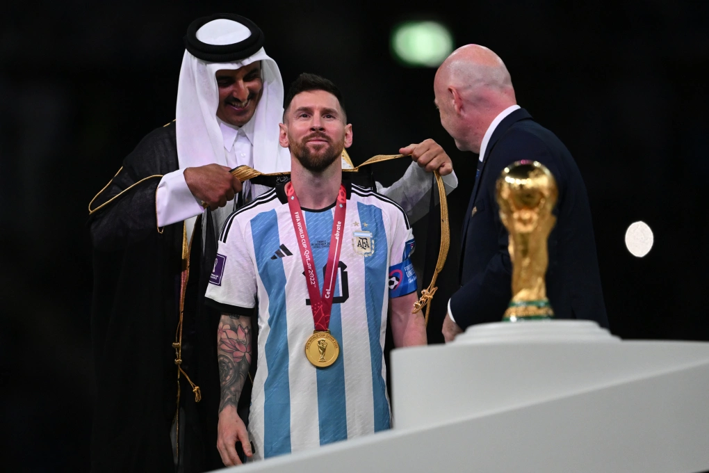 Tiểu vương Qatar (trái) khoác áo choàng Hồi giáo lên người Messi sau trận chung kết World Cup 2022 ngày 18/12/2022. Ảnh: AFP
