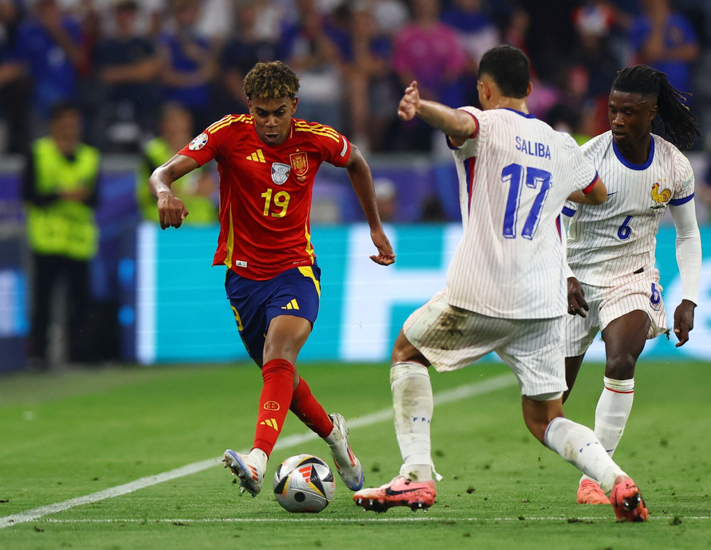 Lamine Yamal (trái) đối đầu với William Saliba và Eduardo Camavinga ở trận bán kết Euro 2024 giữa Pháp và Tây Ban Nha trên sân Munich Football Arena, Munich, Đức ngày 9/7/2024. Ảnh: Reuters