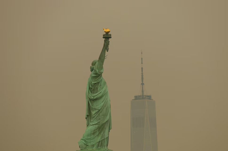 Tượng Nữ thần Tự do tại bến cảng New York nhìn qua làn khói cháy rừng dày đặc ở thành phố Jersey, bang New Jersey, Mỹ, ngày 16/7. Ảnh: Reuters/Mike Segar
