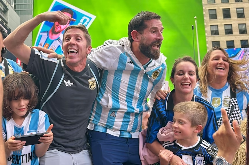 Cổ động viên giống siêu sao Lionel Messi (giữa) được nhiều người vây quanh. Ảnh: ABC